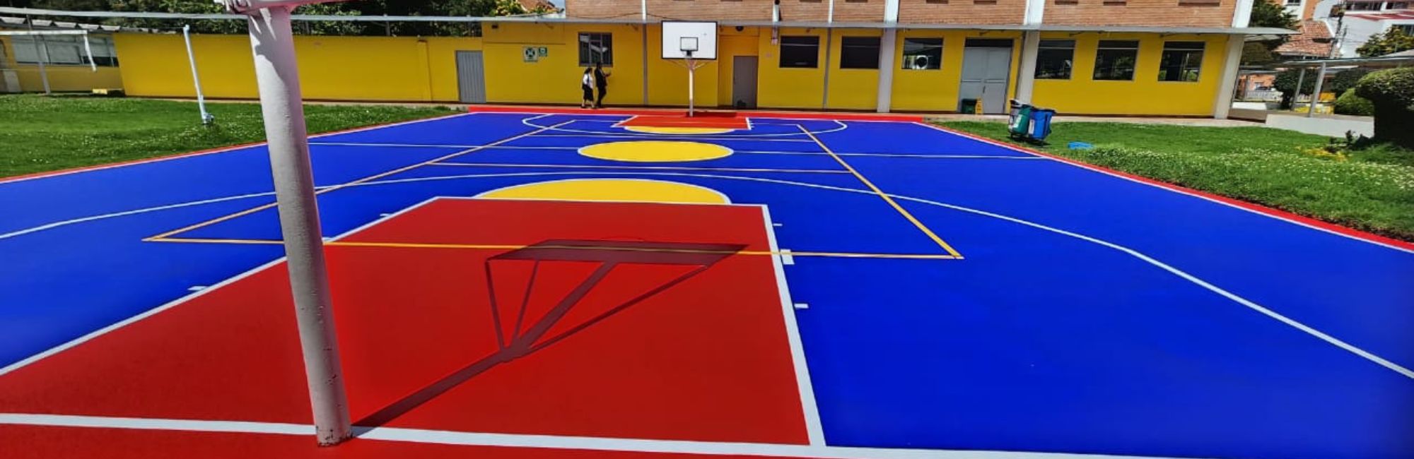 cancha deportiva multiuso de colores amarillo azul y rojo en conjunto residencia